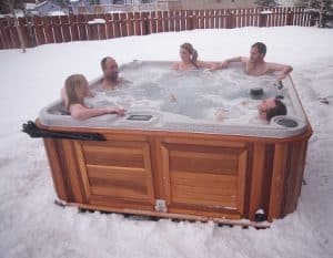 Friends chatting in a hot tub in winter.